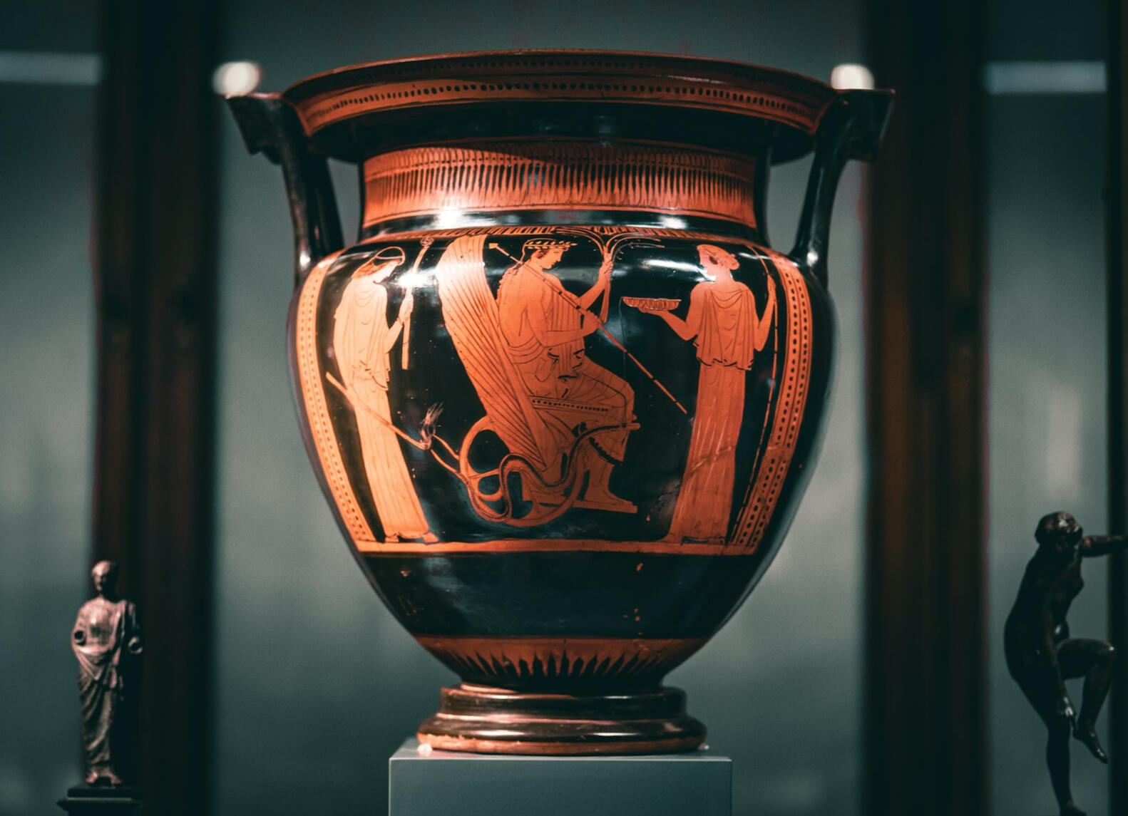 A photograph of an ancient Greek vase painted with an abduction seen in red-figure vase painting style.